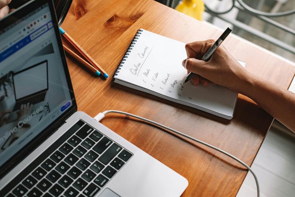 Freelance définissant ses priorités professionnelles pour l’année à venir à l’aide d’un carnet de notes