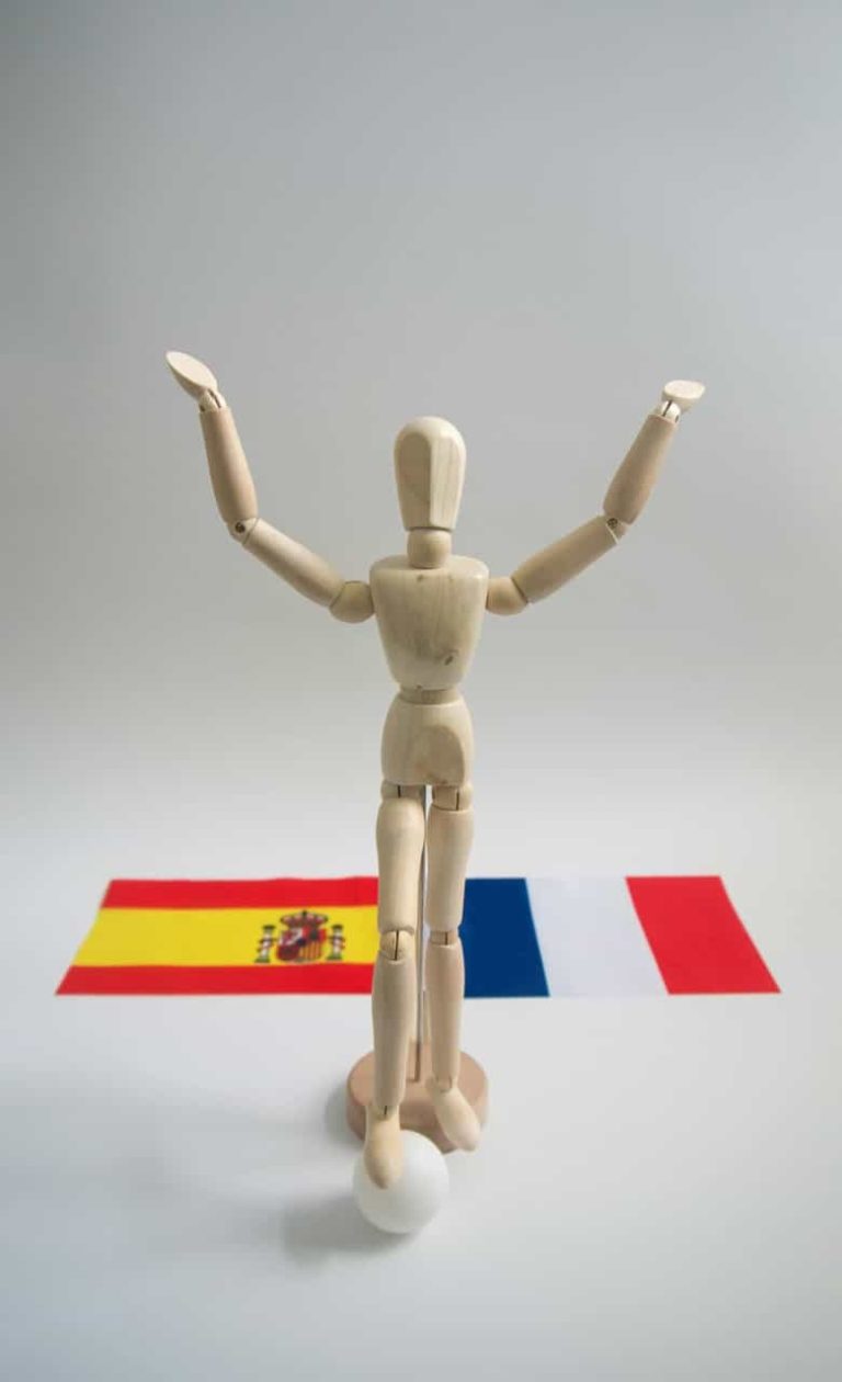 Mannequin de bois devant les drapeaux anglais et espagnol.